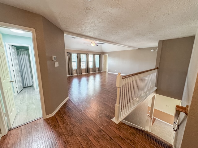 hallway featuring wood-type flooring and a textured ceiling