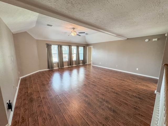 empty room with a textured ceiling, ceiling fan, dark wood-type flooring, and vaulted ceiling