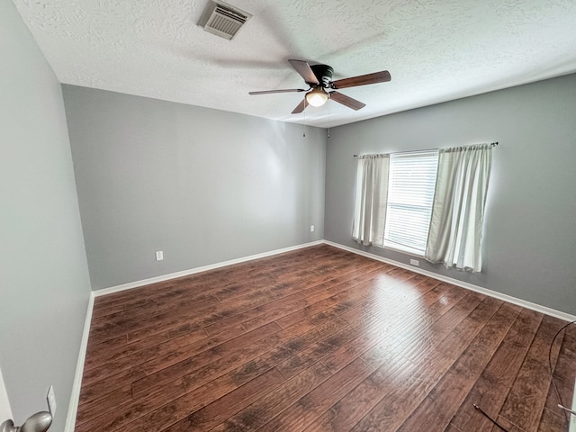 spare room with dark hardwood / wood-style floors, ceiling fan, and a textured ceiling