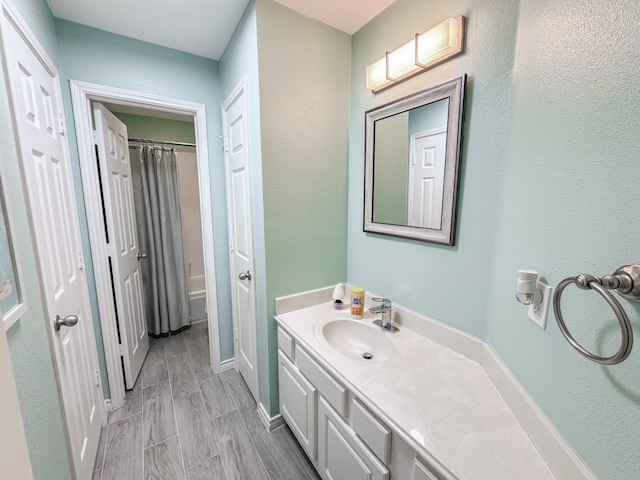 bathroom with shower / tub combo with curtain, vanity, and wood-type flooring