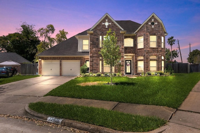 front of property with a garage and a lawn