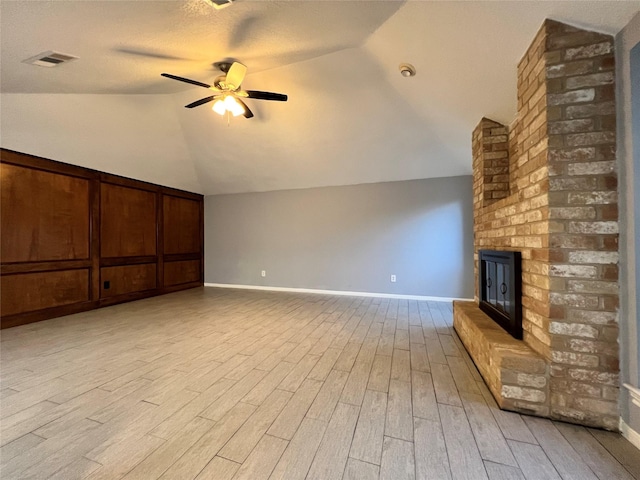 interior space with ceiling fan, light wood-type flooring, lofted ceiling, and a textured ceiling