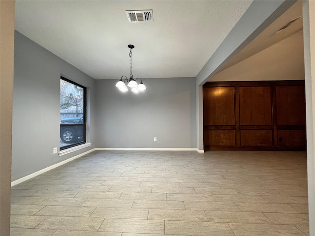 unfurnished room with a notable chandelier