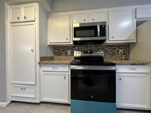 kitchen with dark stone counters, white cabinets, and stainless steel appliances