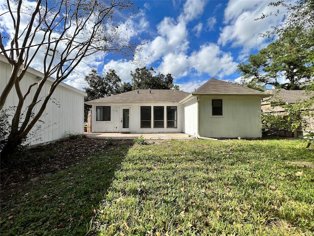 rear view of house featuring a patio and a lawn