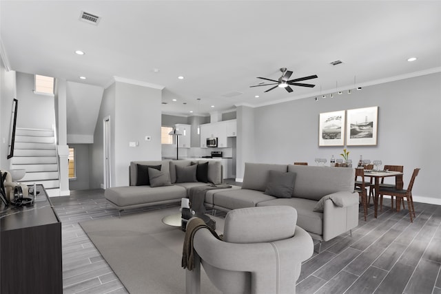 living room with hardwood / wood-style floors, ceiling fan, and ornamental molding