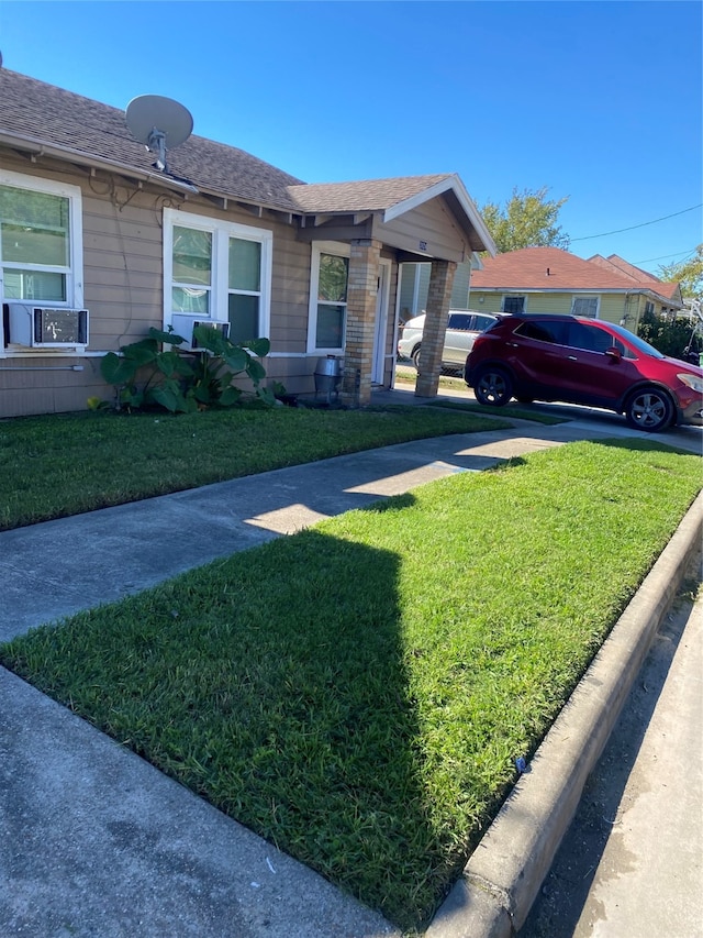 view of front of property with cooling unit and a front yard