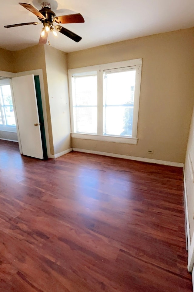 unfurnished room with ceiling fan, dark hardwood / wood-style flooring, and a wealth of natural light