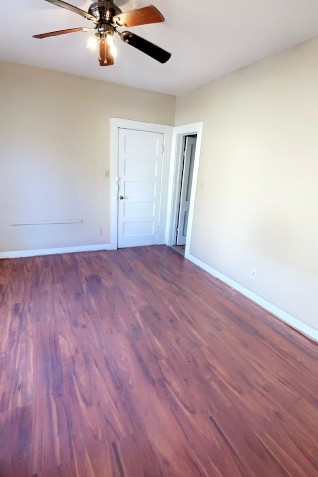 spare room with dark hardwood / wood-style floors and ceiling fan