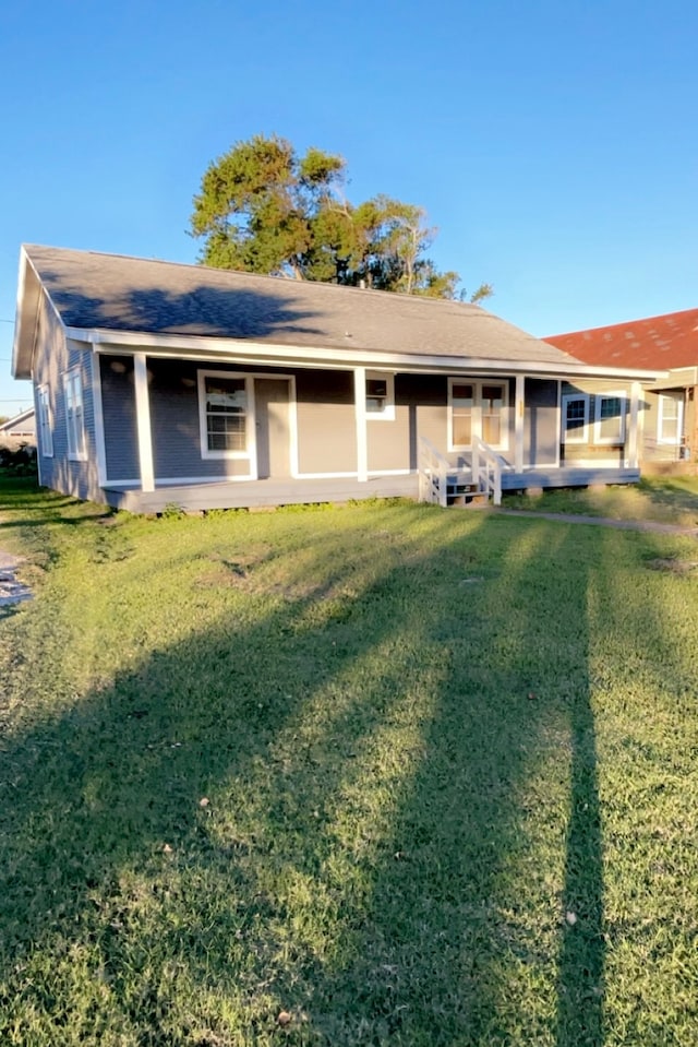 rear view of house featuring a lawn