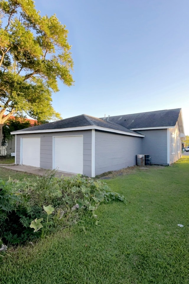 exterior space featuring a garage and a lawn