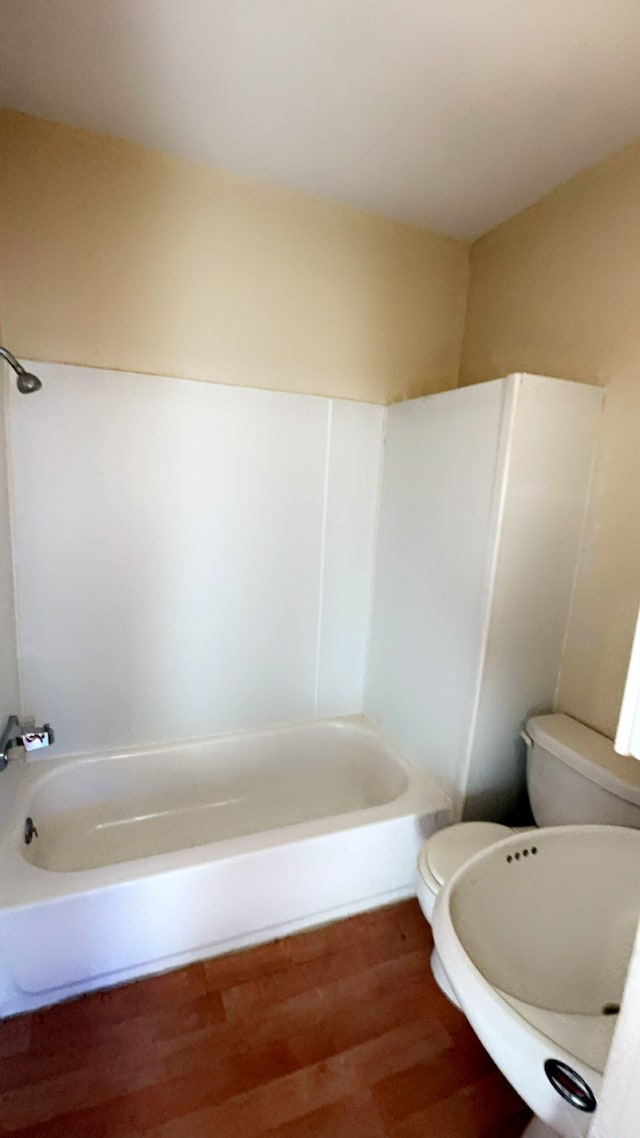 bathroom with toilet, wood-type flooring, and shower / washtub combination