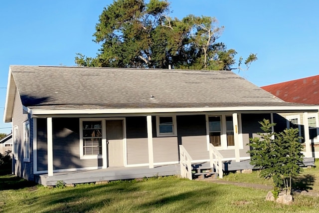 back of property featuring a lawn and covered porch