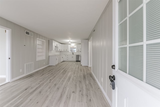 unfurnished living room with light wood-type flooring and sink