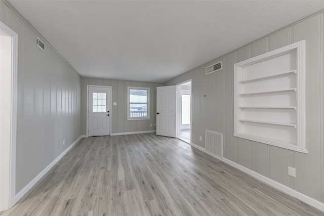 foyer entrance featuring light hardwood / wood-style floors and a textured ceiling