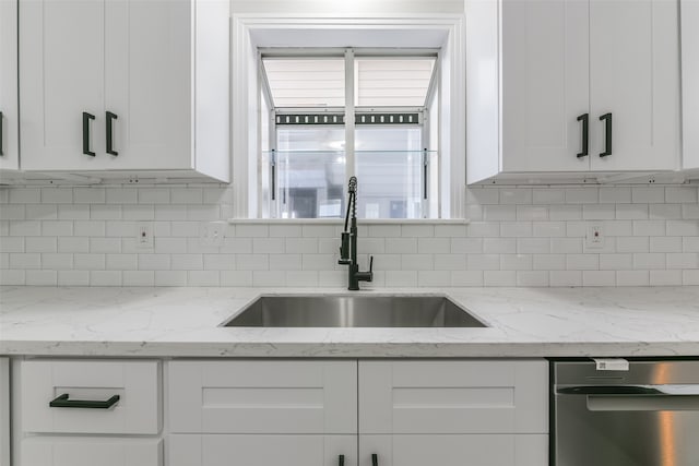 kitchen with dishwasher, sink, white cabinets, and light stone countertops