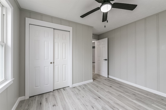 unfurnished bedroom with ceiling fan, a closet, and light hardwood / wood-style flooring