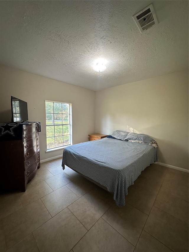 bedroom featuring light tile patterned floors, a textured ceiling, and billiards