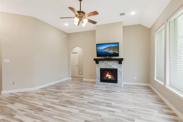 16979 Concord Dr, Conroe, TX 77385 - unfurnished living room with light wood-type flooring, a ceiling fan, a high end fireplace, arched walkways, and healthy amount of natural light