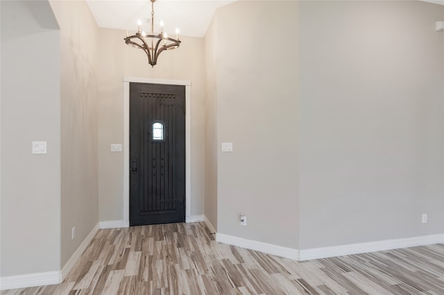 foyer entrance with a notable chandelier and light hardwood / wood-style floors