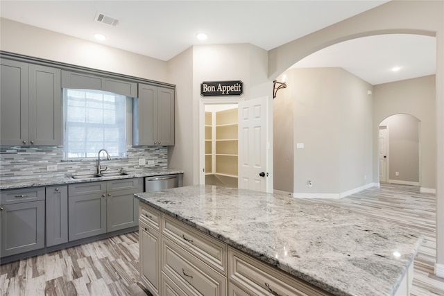 kitchen featuring light hardwood / wood-style floors, light stone counters, and sink