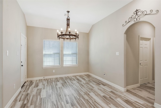 16979 Concord Dr, Conroe, TX 77385 - spare room featuring light wood finished floors, a chandelier, arched walkways, baseboards, and lofted ceiling
