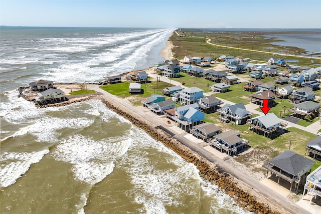 birds eye view of property with a water view and a view of the beach