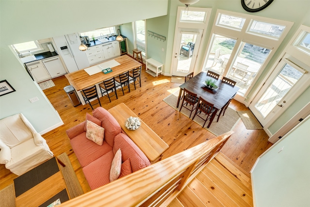 living room with light hardwood / wood-style floors and a towering ceiling