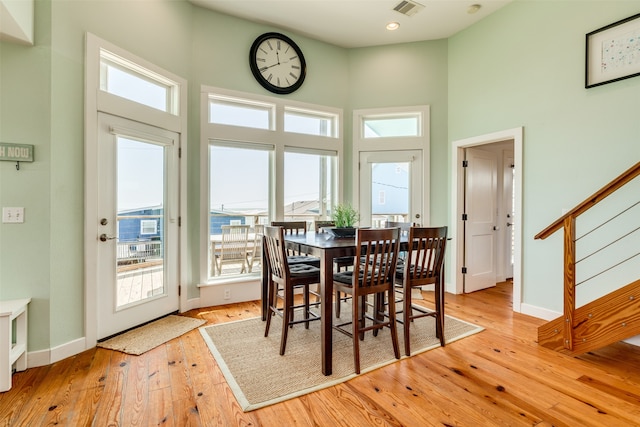 dining space featuring a high ceiling and light wood-type flooring