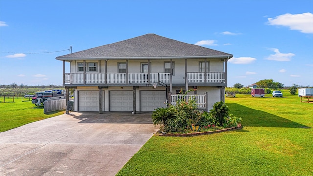 view of front of property with covered porch, a front yard, and a garage