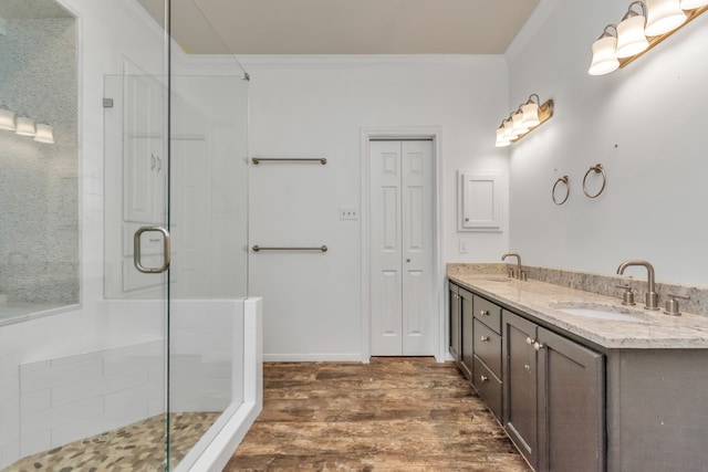 bathroom featuring vanity, hardwood / wood-style flooring, walk in shower, and ornamental molding