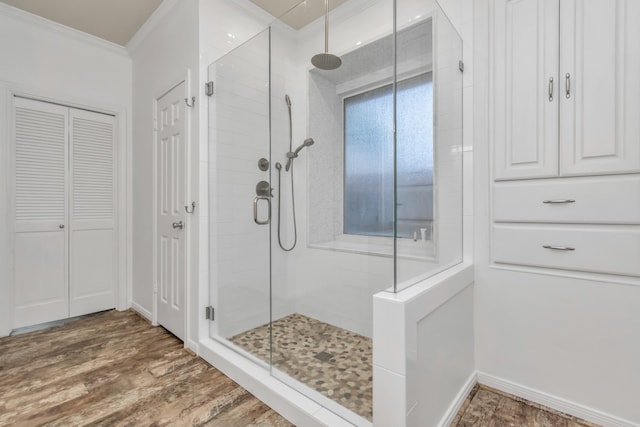 bathroom with wood-type flooring, walk in shower, and crown molding