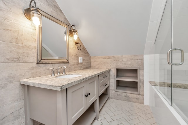 bathroom with vanity, tile walls, and lofted ceiling