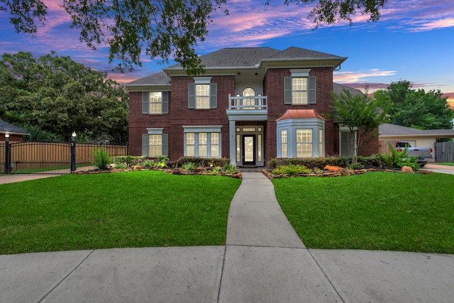 view of front of home featuring a yard and a balcony