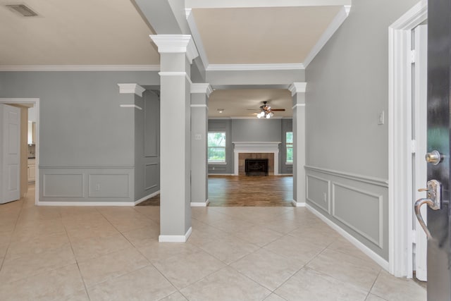 foyer entrance with ceiling fan, ornate columns, and crown molding