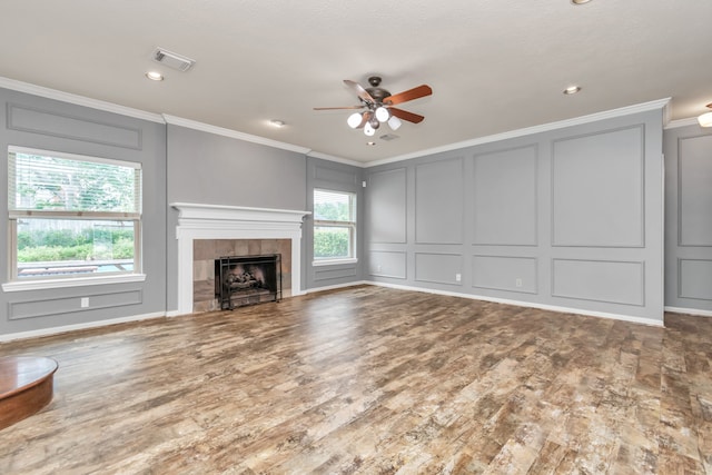 unfurnished living room with ceiling fan, crown molding, wood-type flooring, and a fireplace