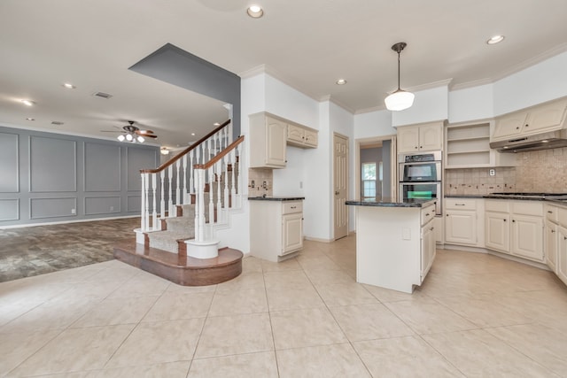 kitchen featuring ornamental molding, stainless steel appliances, ceiling fan, pendant lighting, and a center island