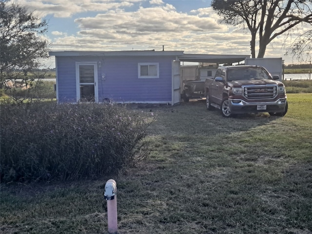 exterior space featuring a front lawn and a carport