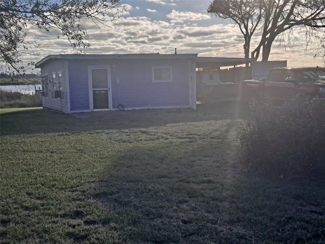 back house at dusk with a lawn