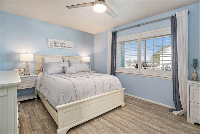 bedroom with light hardwood / wood-style floors and ceiling fan