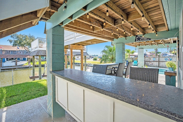 view of patio with a water view and an outdoor bar