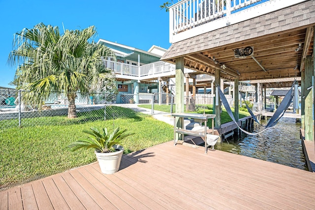 view of dock featuring a lawn and a water view