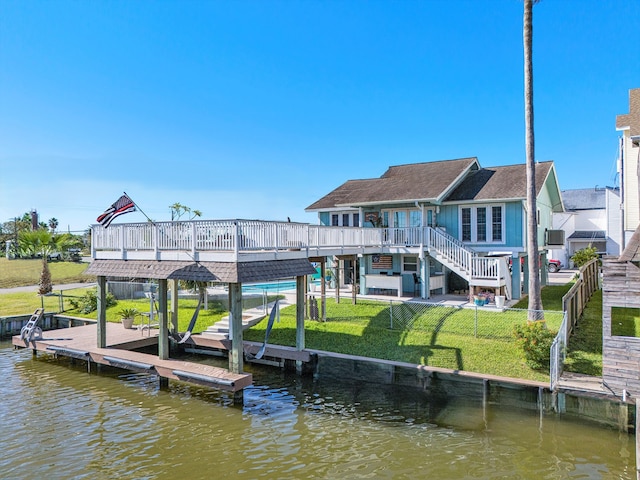 dock area featuring a lawn and a deck with water view