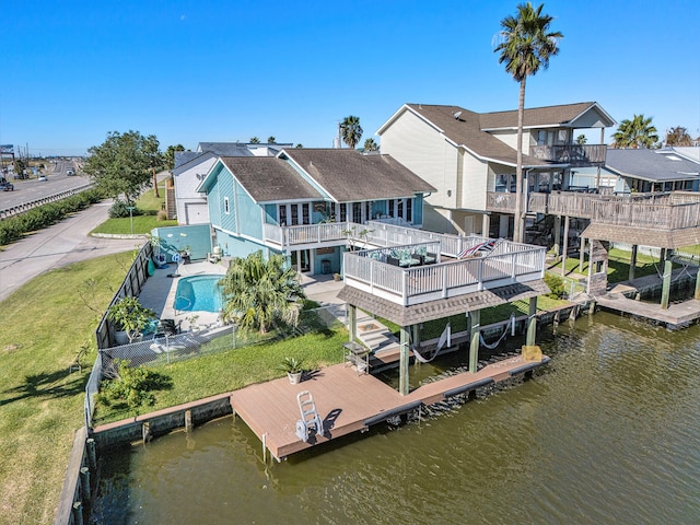 exterior space featuring a yard and a swimming pool side deck with water view