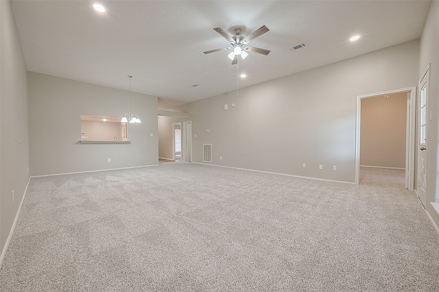 carpeted empty room with ceiling fan with notable chandelier