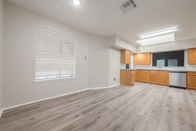 kitchen featuring dishwasher, sink, a textured ceiling, and light hardwood / wood-style flooring