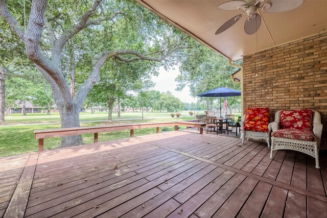 deck featuring a yard and ceiling fan