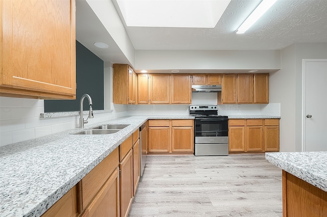 kitchen with light stone countertops, sink, stainless steel appliances, light hardwood / wood-style flooring, and decorative backsplash