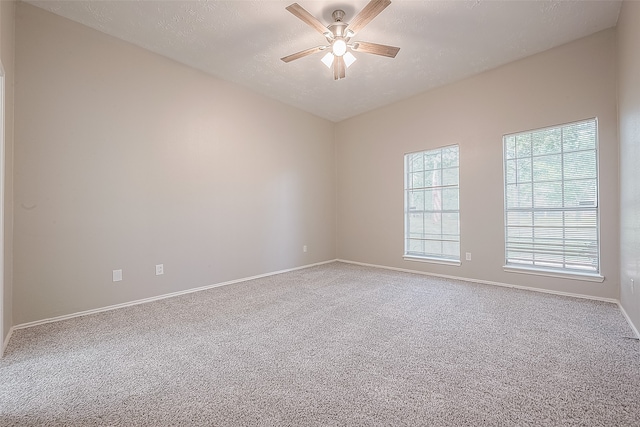 carpeted spare room with ceiling fan and a textured ceiling