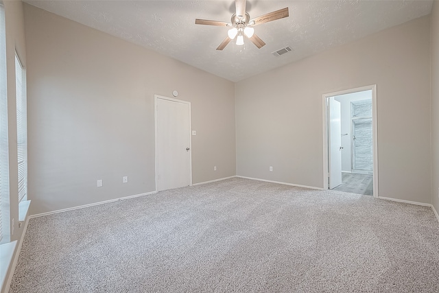 unfurnished room with ceiling fan, light colored carpet, and a textured ceiling